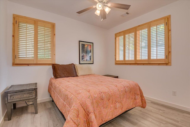 bedroom featuring wood finished floors, baseboards, and a ceiling fan
