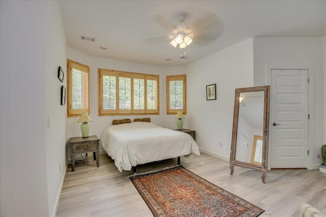 bedroom with light wood-style floors, baseboards, and ceiling fan