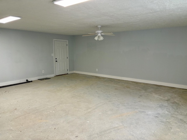 spare room featuring a textured ceiling, visible vents, ceiling fan, baseboards, and concrete flooring