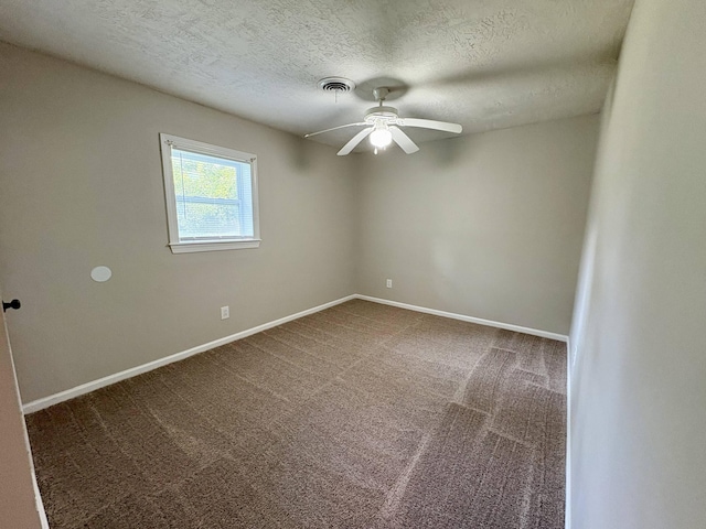 spare room with a textured ceiling, a ceiling fan, carpet floors, and baseboards