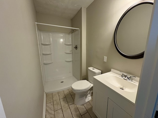 bathroom featuring marble finish floor, toilet, a shower, and vanity