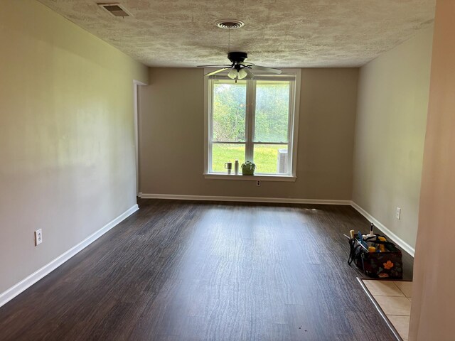 unfurnished room featuring baseboards, visible vents, wood finished floors, and ceiling fan
