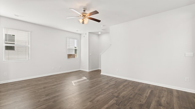 spare room featuring dark wood-type flooring and ceiling fan