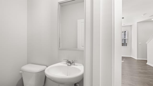 bathroom with sink, hardwood / wood-style flooring, and toilet