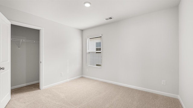 unfurnished bedroom featuring a closet and light carpet