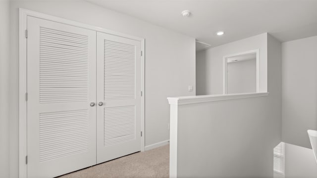 hallway featuring light colored carpet