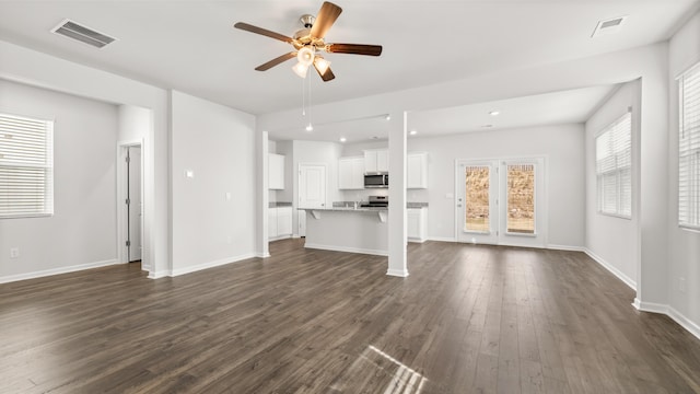 unfurnished living room with dark wood-type flooring and ceiling fan