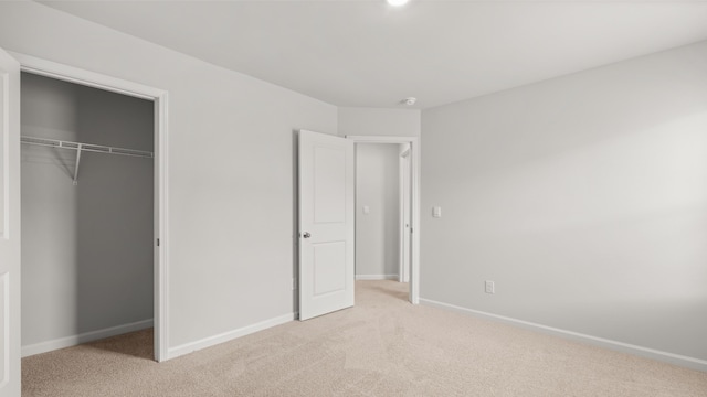 unfurnished bedroom with light carpet and a closet