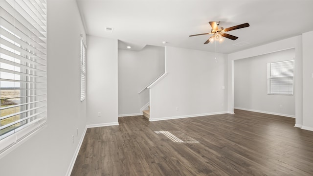 unfurnished living room featuring ceiling fan and dark hardwood / wood-style flooring