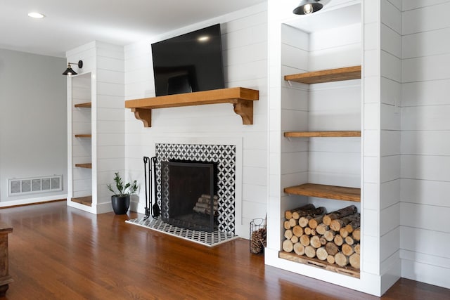 living room with dark hardwood / wood-style flooring and a tile fireplace