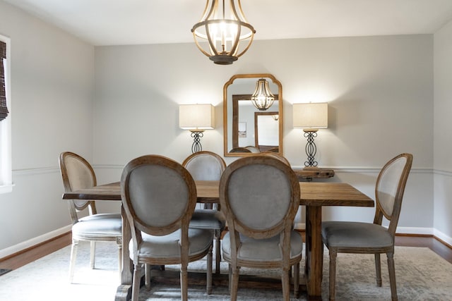 dining area with dark hardwood / wood-style flooring and a notable chandelier