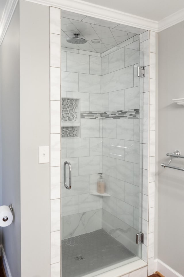 bathroom featuring crown molding and a shower with shower door