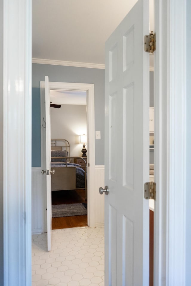 corridor featuring crown molding and light tile patterned flooring