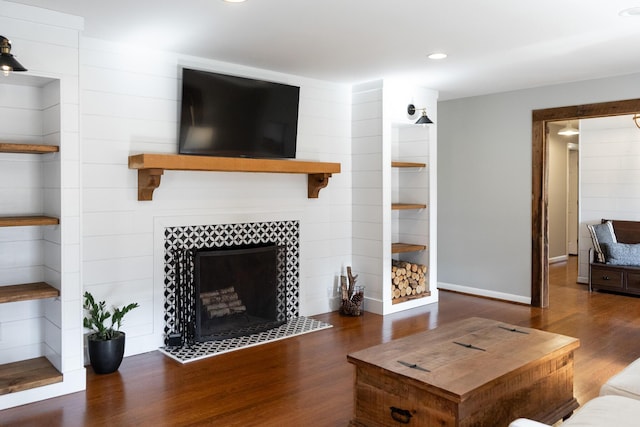 living room featuring dark wood-type flooring and a fireplace