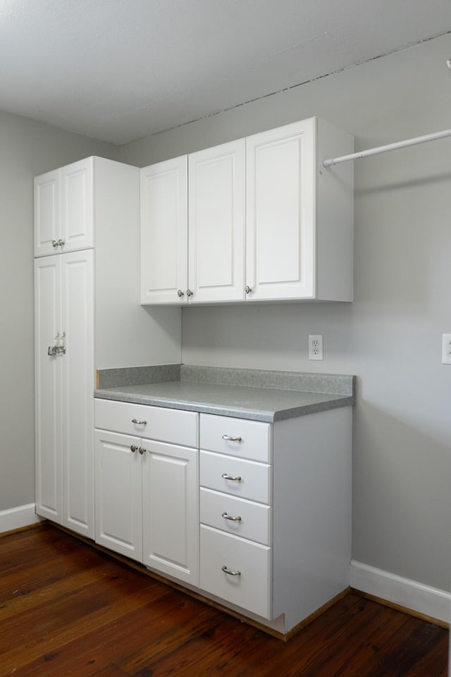 kitchen with dark wood-type flooring and white cabinets