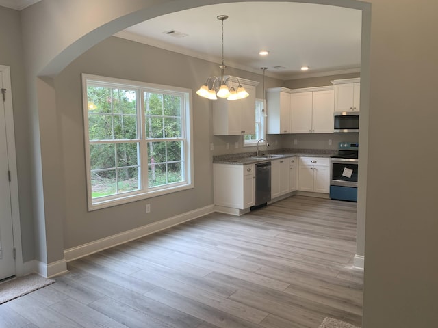 kitchen featuring light wood finished floors, white cabinetry, stainless steel appliances, and a sink