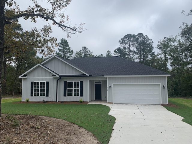 single story home with driveway, a front lawn, roof with shingles, and an attached garage