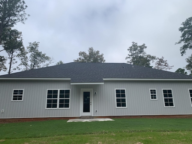 view of front of house with a front lawn and roof with shingles