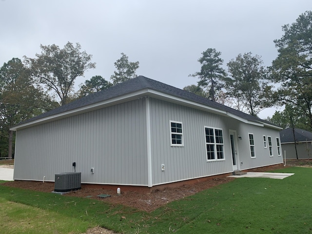 view of home's exterior with a lawn and central AC