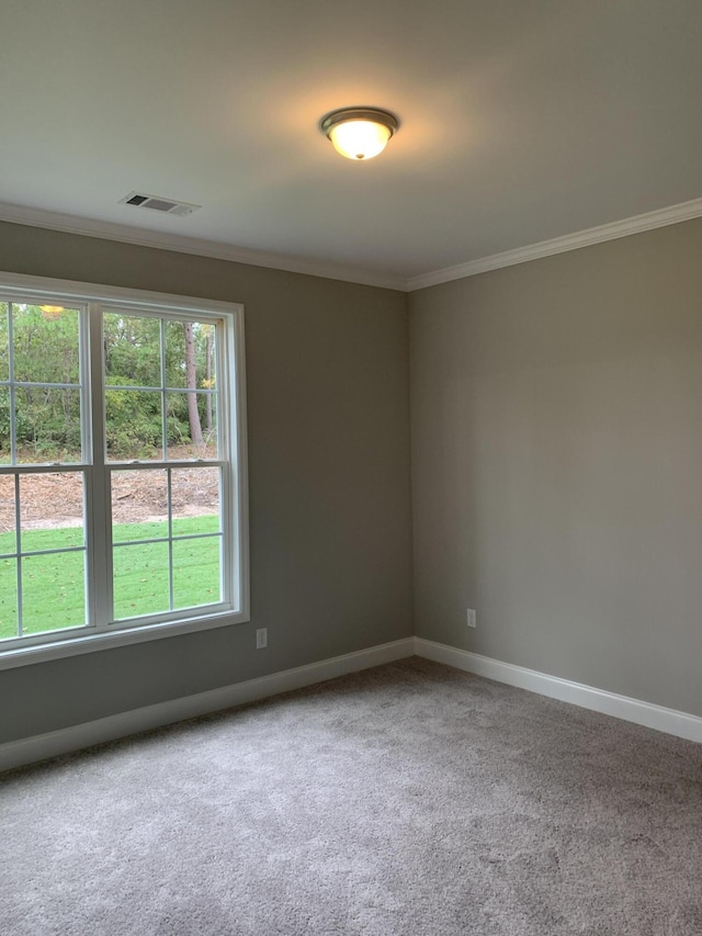 carpeted spare room featuring ornamental molding, visible vents, and baseboards