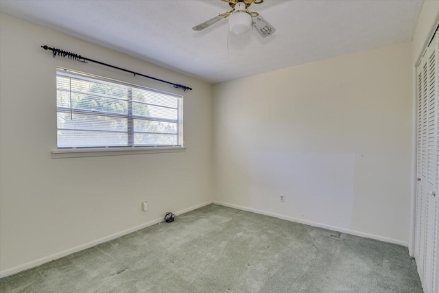 unfurnished bedroom with ceiling fan, a closet, and light carpet