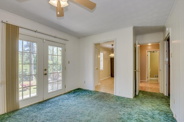 interior space featuring ornamental molding, light colored carpet, french doors, and ceiling fan