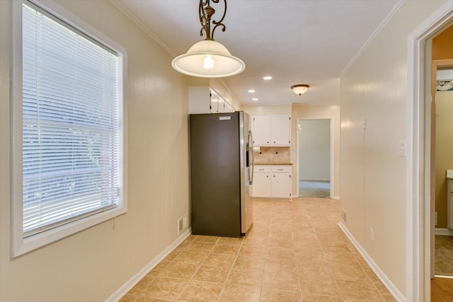 hall with crown molding and light tile patterned floors