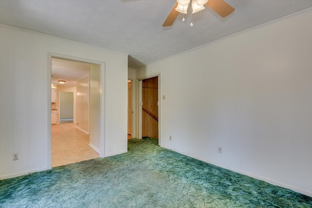 carpeted empty room with ceiling fan and ornamental molding