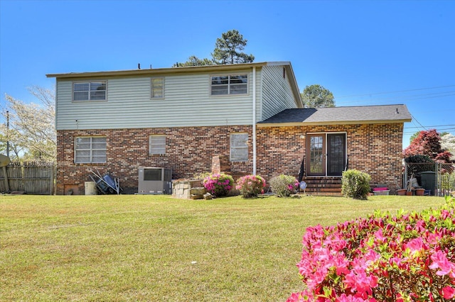 back of property featuring central AC and a lawn