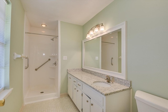 bathroom featuring vanity, a shower, tile patterned floors, and toilet