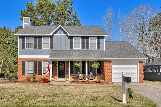 traditional-style house featuring covered porch, concrete driveway, a front lawn, a garage, and brick siding