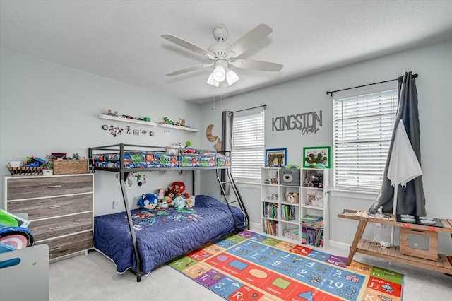 carpeted bedroom featuring baseboards, a textured ceiling, and a ceiling fan