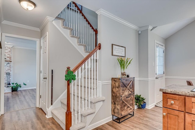 staircase with baseboards, wood finished floors, and crown molding