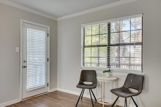 living area featuring a wealth of natural light, crown molding, baseboards, and wood finished floors