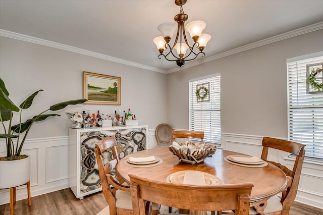 dining room with a wainscoted wall, wood finished floors, and a chandelier