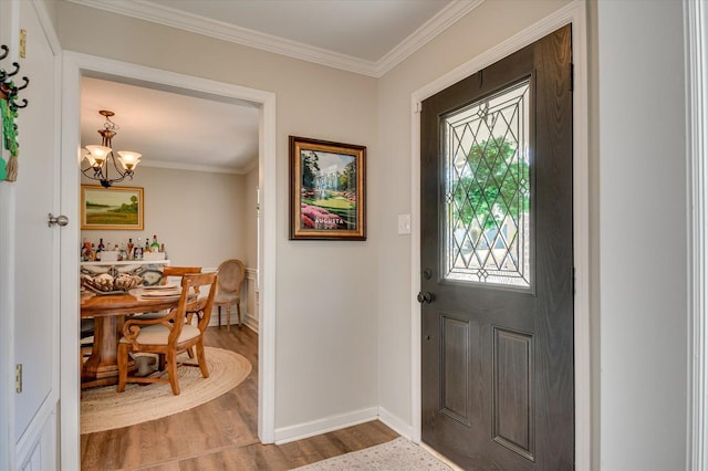 entryway with baseboards, an inviting chandelier, wood finished floors, and ornamental molding