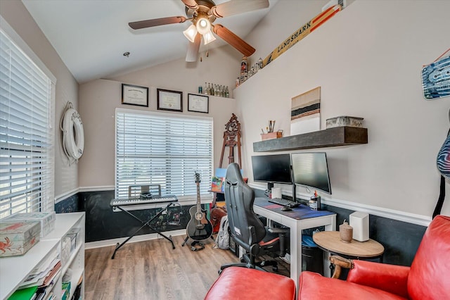 office space featuring lofted ceiling, plenty of natural light, wood finished floors, and a ceiling fan