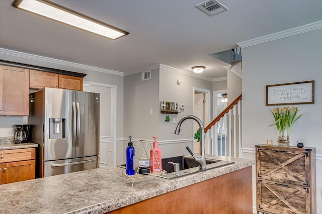 kitchen featuring light countertops, stainless steel fridge with ice dispenser, visible vents, and a sink