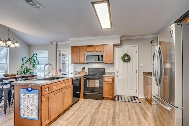 kitchen with visible vents, a peninsula, a sink, black appliances, and a chandelier