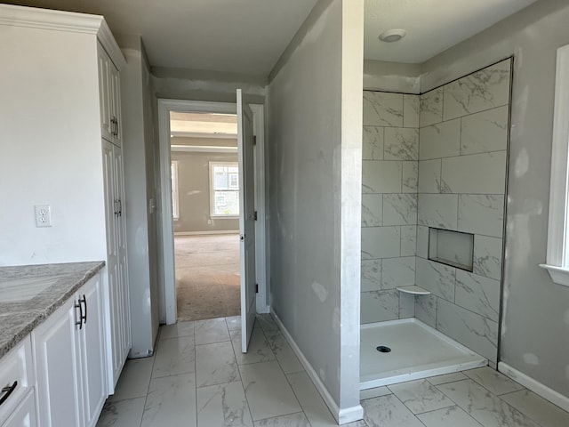 full bath with baseboards, marble finish floor, a stall shower, and vanity