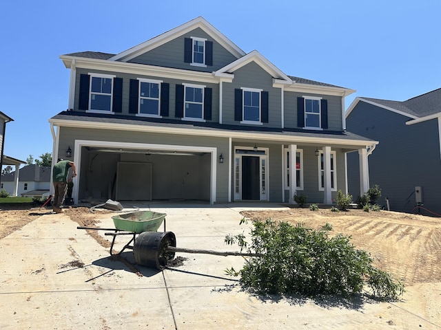 view of front of house with a porch, an attached garage, and driveway