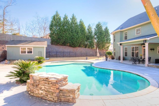 view of pool featuring an outbuilding and a patio