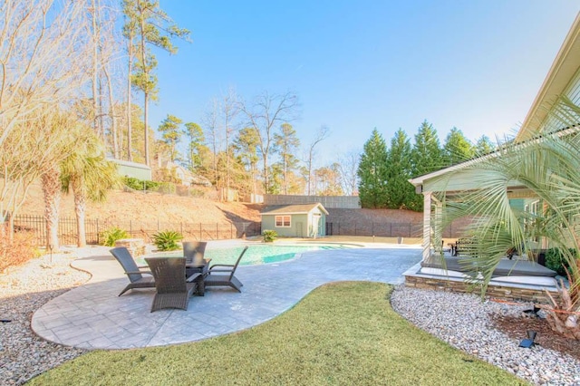 view of yard with a storage shed, a fenced in pool, and a patio