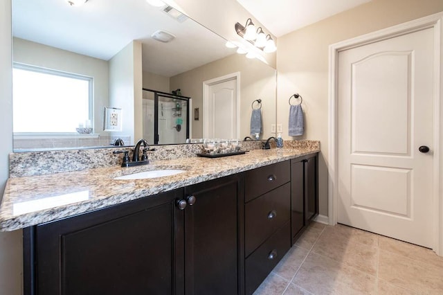 bathroom with tile patterned flooring, a shower with door, and vanity