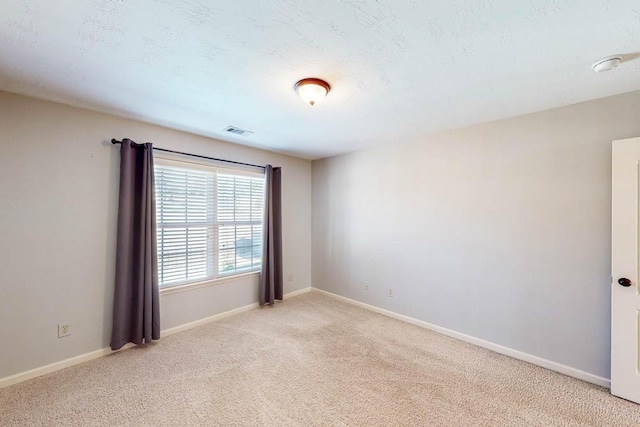 spare room featuring light carpet