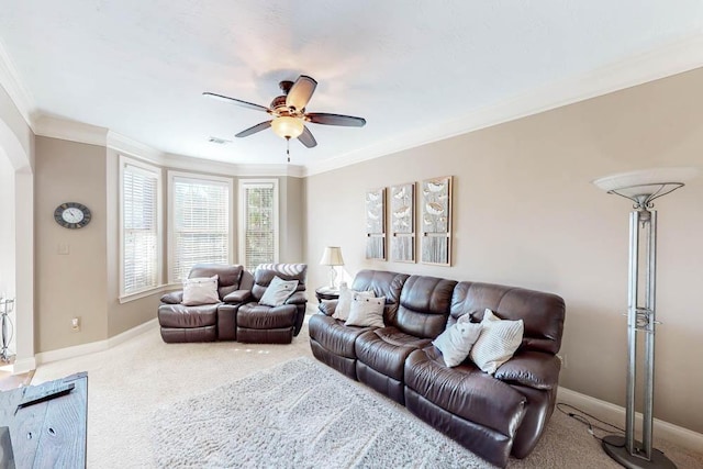 living room with carpet floors, ornamental molding, and ceiling fan