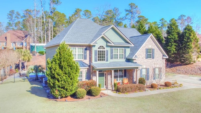 view of front of house with covered porch and a front lawn