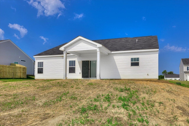 rear view of property featuring a yard