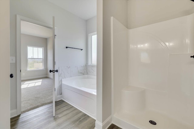 bathroom with hardwood / wood-style floors and a tub