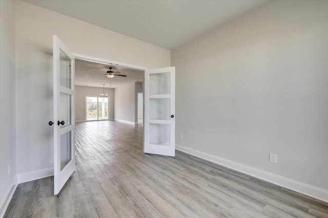 empty room featuring ceiling fan, light wood-type flooring, and french doors